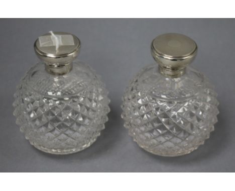 A pair of George V engine turned silver topped cut glass globular scent bottles, GW, London, 1920, 12.5cm.