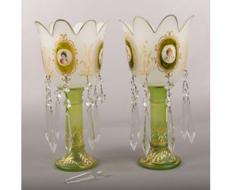 A pair of decorative glass lustres, with transfer print portrait panels and green and gilt decoration. (Height 16.5cm).  Crac