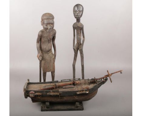 Two African wood carvings along with wooden a model boat.  Wooden boat for restoration.