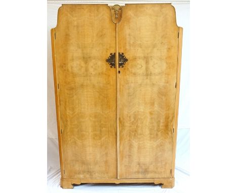 1950's PALE WALNUT WARDROBE
with two shaped doors flanking a central decorative shell motif, standing on bracket feet, 122cm 