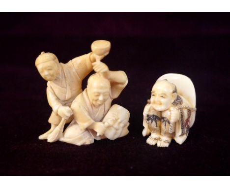 JAPANESE CARVED IVORY NETSUKE
of a boy kneeling with a Noh mask on his back, 3.7cm high; and a carved ivory netsuke of a carv
