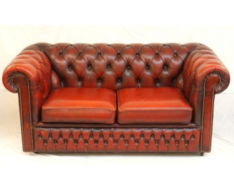 LEATHER CHESTERFIELD BUTTON BACK TWO SEAT SOFA
in ox blood red leather with stud detail, on castors, 164cm wide 