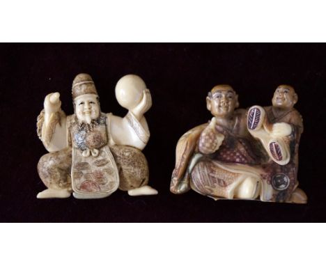 CARVED IVORY NETSUKE
of a man seated with a boy on his shoulder, 3.5cm high; and a carved ivory netsuke of a performer holdin