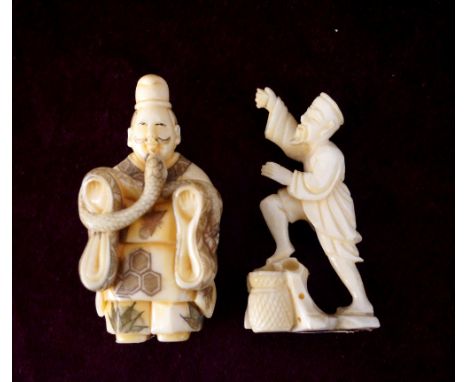 JAPANESE CARVED IVORY NETSUKE
of a man holding a snake, 6cm high; and an ivory carving of a fisherman standing on a rock with