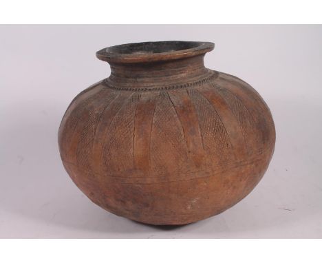 An Abuja pottery water or grain bowl, the unglazed brown clay vessel of round form, the body decorated with cross hatched tap
