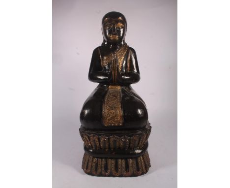 Burmese gilt and lacquered carved wooden monk or Buddhist figure, the figure kneeling in prayer, wearing a scrolled civara in