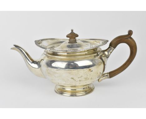 A George V silver teapot by William Neale, Birmingham 1922, the top with gadrooned and shell border, the hinged lid with turn