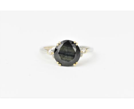 An 18ct white gold, green stone and diamond dress ring, the central stone possibly tourmaline, flanked with three bezel set d