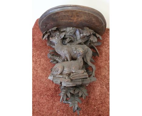 19th/20th C carved oak Black Forrest style wall bracket, the D shaped shelf supported by stag and deer in foliage setting (40