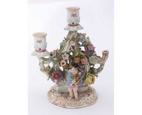 A 19th century Meissen porcelain three-light candelabra, ornately decorated with moulded and painted flowers and one side wit