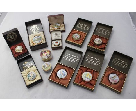 A collection of twelve assorted enamel pill boxes including one by 'Toye, Kenning & Spencer Ltd.' with the top depicting a sc