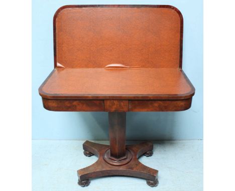 A William IV flame mahogany folding card table, opening to reveal a tan vinyl playing surface and raised on a hexagonal suppo