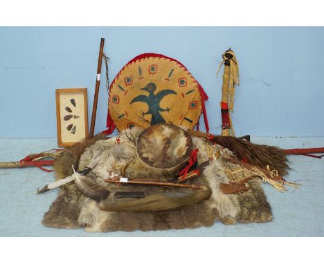A Native American circular leather hide covered shield with painted bird decoration, together with a wooden-handled Tomahawk,