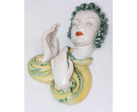A Goldscheider pottery wall mask modelled as a lady smoking a cigarette. 34cm in length. (cigarette broken at butt)