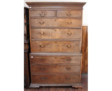 A George III oak chest-on-chest, with ogee cornice and Greek key moulding, two short over six long graduated drawers with ori