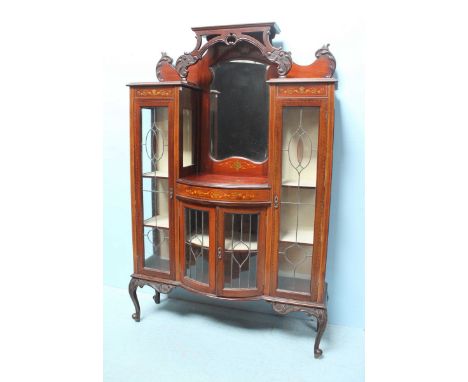 An early 20th century mahogany display cabinet, with a raised back to a central mirror, above two lead-glazed doors enclosing