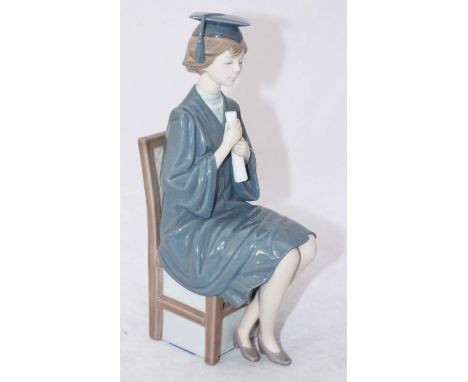 A Lladro porcelain figure of a seated female graduate with mortarboard and scroll. 26cm high.