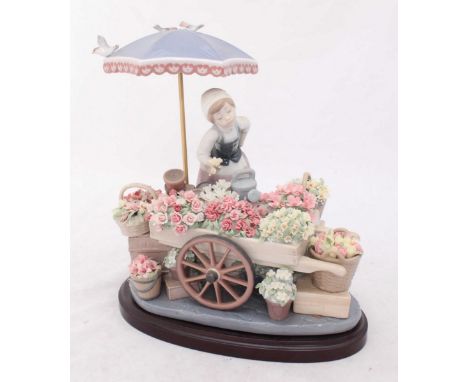 A large Lladro porcelain figurine 'Flowers of the Season' no.1454, depicting a female flower vendor, modelled by Jose Puche, 