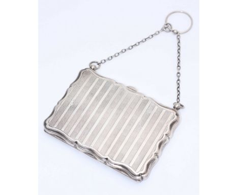 A silver and leather lined purse, of rectangular form with serpentine edges, engine turned decoration, internal propelling pe