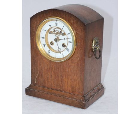 An oak cased mantel clock with white enamel dial, Roman numerals and lions mask handles, movement by H&F Paris, approximately