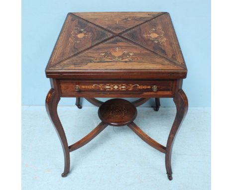 A late Victorian rosewood envelope card table the top decorated with scrolling foliate inlay, opening to reveal a green playi