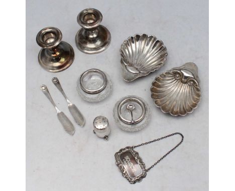 A pair of loaded silver squat candlesticks with detachable drip pans, 7cm high, together with a pair of shell butter dishes a