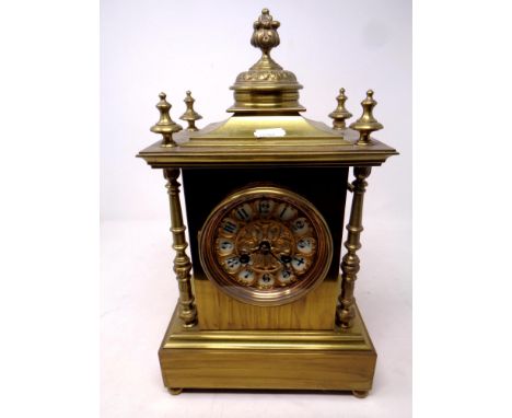 An ornate brass mantel clock on raised feet, with pendulum and key, height 35.5 cm  