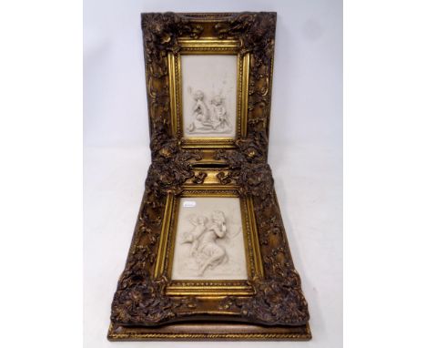 Two ceramic cherub relief plaques in ornate gilt frames, 31 x 26.5 cm 