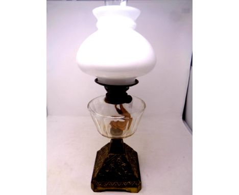 An antique brass oil lamp with clear glass reservoir, chimney and shade, height 55 cm   