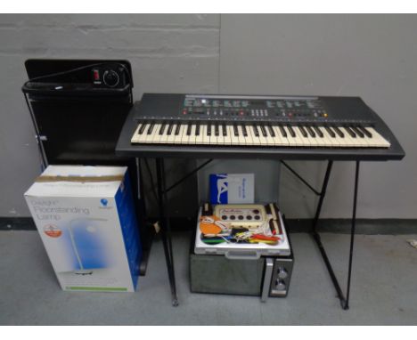 A Yamaha PSR 200 keyboard on stand together with a Hinari microwave, a Corby trouser press, a floor standing lamp and an elec