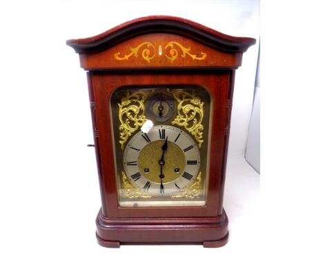 An early 20th century mahogany cased bracket clock with decorative brass dial, pendulum and key  