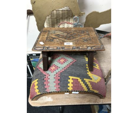 An antique carved oak footstool together with a further arched footstool upholstered in a tapestry fabric 