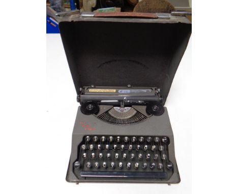 A vintage The Baby Empire typewriter in case 