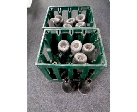 Two plastic brewery crates containing twelve vintage green glass wine bottles   