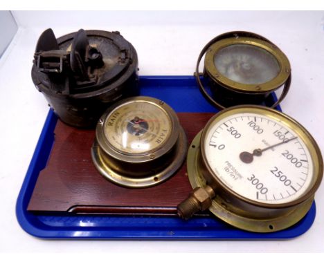 Two vintage ship's compasses together with a brass cased pressure gauge and a brass cased barometer mounted on a board 