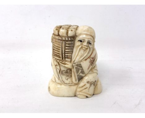 A Japanese carved bone netsuke - Village elder carrying a basket of wares on his shoulder. 