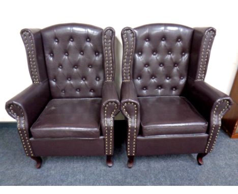A pair of button vinyl wingback armchairs 