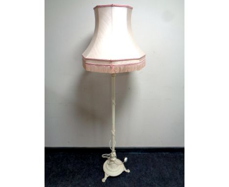 A cast iron painted standard lamp with tasseled shade  