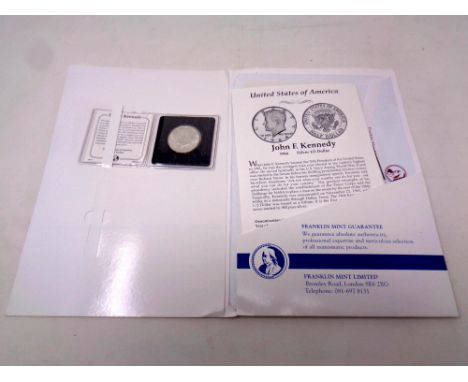 A Franklin Mint John F Kennedy 1964 silver half dollar with certificate in folder together with a case containing a silver ha