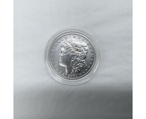 Carson City Mint. The obverse side features Liberty in profile. She is shown in cap, flora, and crown. The reverse side depic