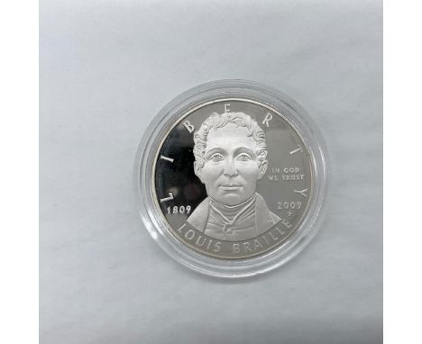 Philadelphia Mint. The obverse side depicts a portrait likeness of Louis Braille. The reverse side features a child reading a