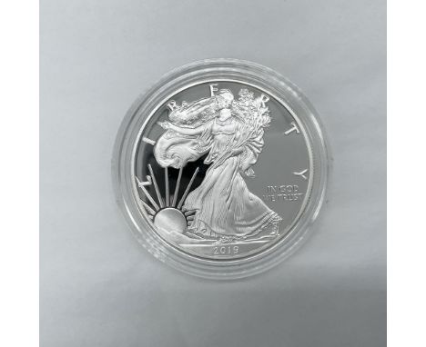 San Francisco Mint. The obverse side depicts Liberty in full stride. She is shown wrapped in the flag, her right hand is exte