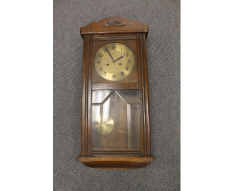 An early twentieth century oak cased wall clock with Junghans movement, pendulum and key 