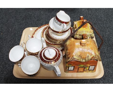 A tray containing a twenty-two piece Royal Stafford bone china tea service together with a cottage ware teapot and lidded bis