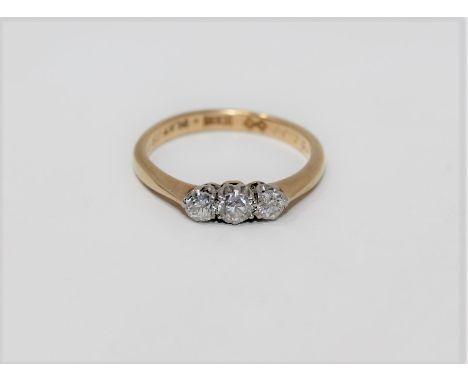 An 18ct gold three stone diamond ring, approximately 0.33 carat, size K1/2