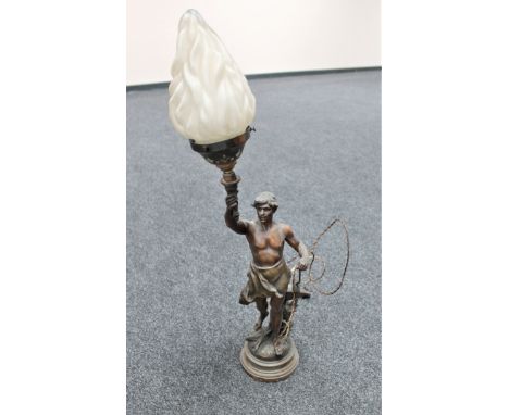 A late 19th century spelter figural table lamp modelled as a blacksmith holding torch aloft