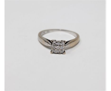 An 18ct white gold diamond set cluster ring, approximately 0.14 carat, size K