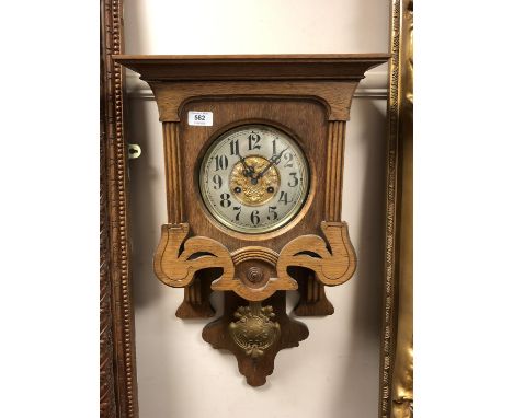 An Edwardian oak wall clock with pendulum 