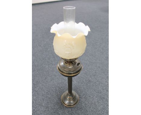 A late 19th century brass oil lamp with opaque glass shade and chimney 