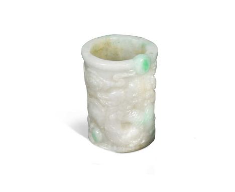 A Chinese jade archers thumb ring or band, probably Republic Period, carved in relief with two dragons chasing the cosmic pea